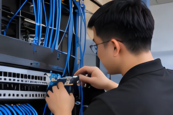 Kỹ thuật viên kiểm tra dây cáp mạng trong tủ rack khi bảo trì