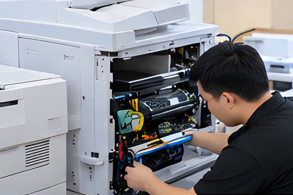 Kỹ thuật viên kiểm tra bên trong máy photocopy đã mở nắp