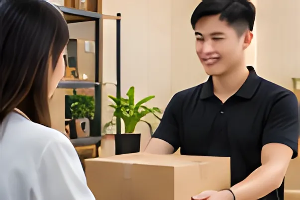 Nhân viên giao thùng hàng cho khách tại cửa hàng